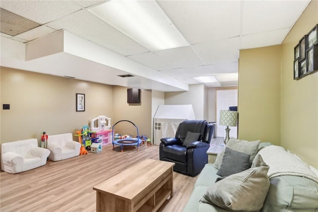 game room featuring light wood-type flooring and a drop ceiling