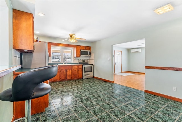 kitchen with ceiling fan, appliances with stainless steel finishes, a wall mounted AC, and sink