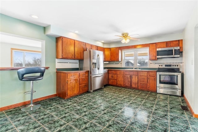 kitchen with stainless steel appliances, sink, a wealth of natural light, and decorative backsplash