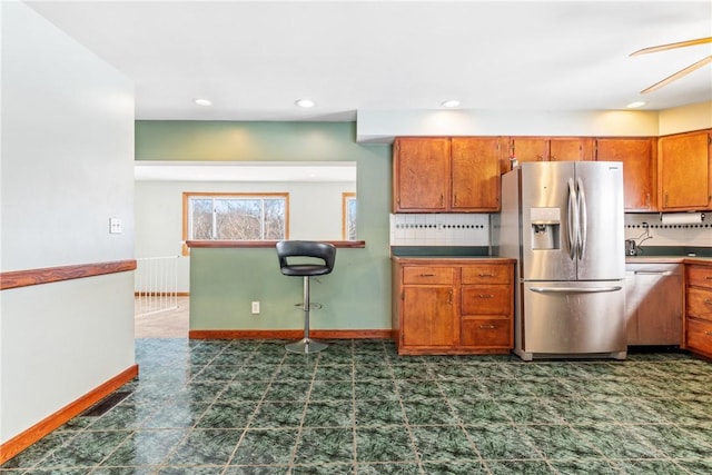 kitchen with backsplash, ceiling fan, and appliances with stainless steel finishes