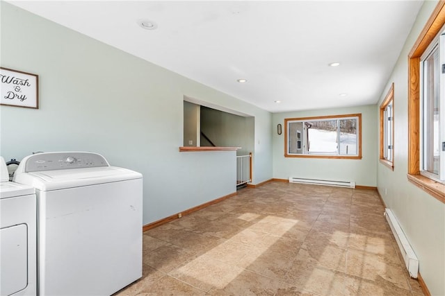 clothes washing area featuring a baseboard heating unit and washer and clothes dryer