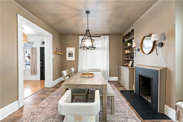 dining space featuring plenty of natural light, dark wood-type flooring, and built in shelves