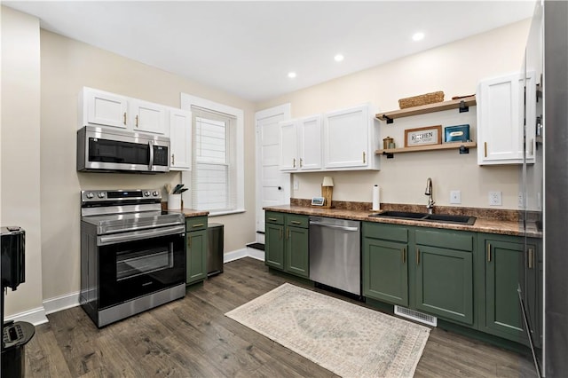 kitchen featuring sink, dark wood-type flooring, green cabinets, white cabinetry, and appliances with stainless steel finishes