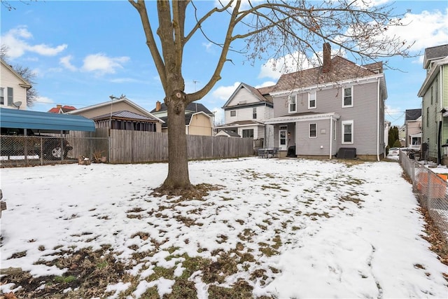 snow covered house featuring central AC unit