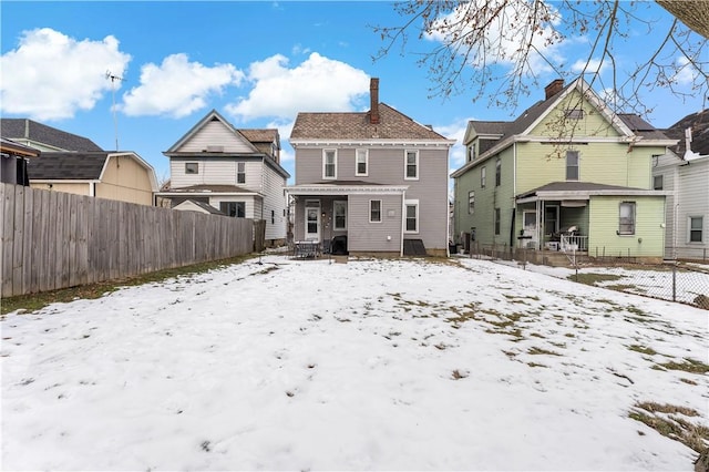 snow covered property with covered porch