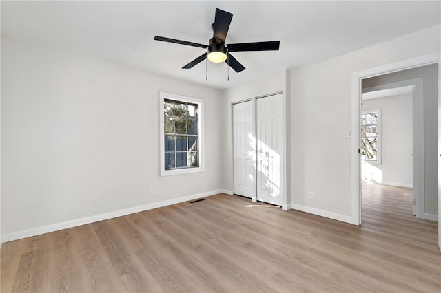 unfurnished bedroom with multiple windows, ceiling fan, and light hardwood / wood-style flooring