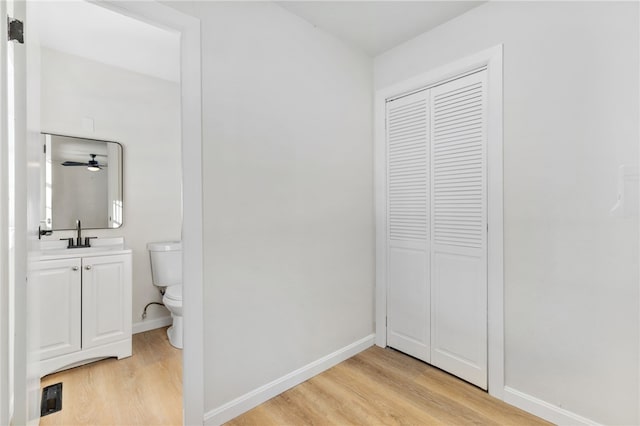 bathroom with vanity, wood-type flooring, and toilet