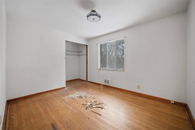 unfurnished bedroom featuring hardwood / wood-style floors and a closet