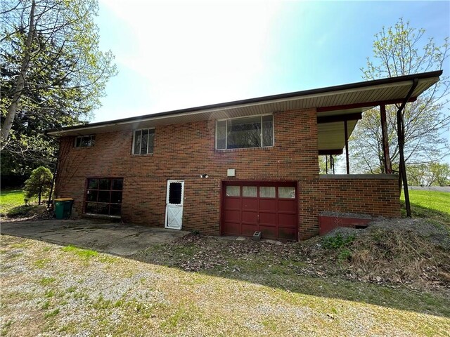 2461 Henry Ln, Franklin Park, PA 15143 - rear view of house featuring an attached garage, brick siding, and driveway