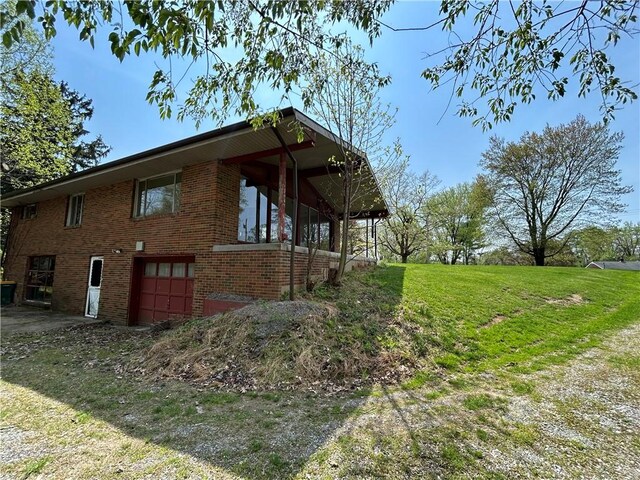 2461 Henry Ln, Franklin Park, PA 15143 - view of side of property with a garage, brick siding, and a lawn