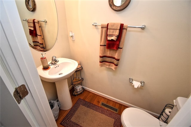 bathroom with hardwood / wood-style floors, sink, and toilet