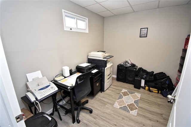 office space with a drop ceiling and light wood-type flooring