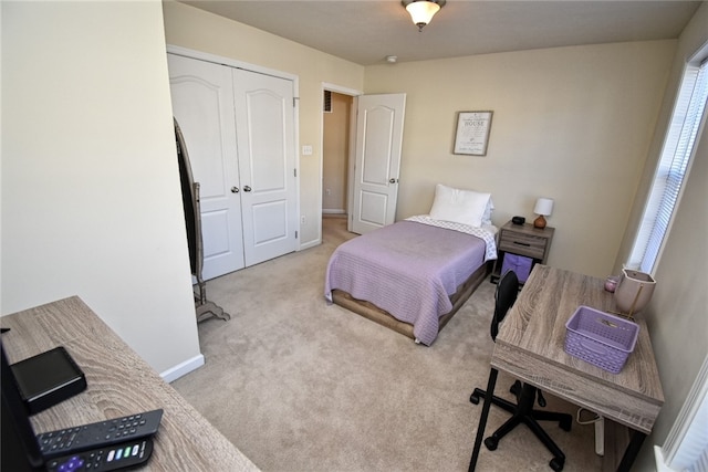 bedroom featuring light carpet and a closet