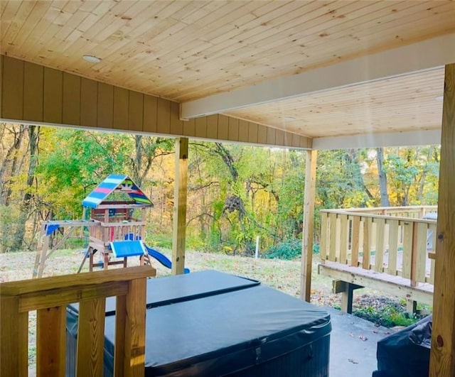 wooden terrace with a playground and a hot tub