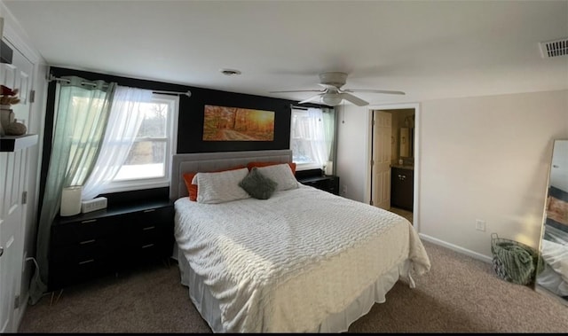 bedroom featuring dark colored carpet, ceiling fan, and ensuite bath