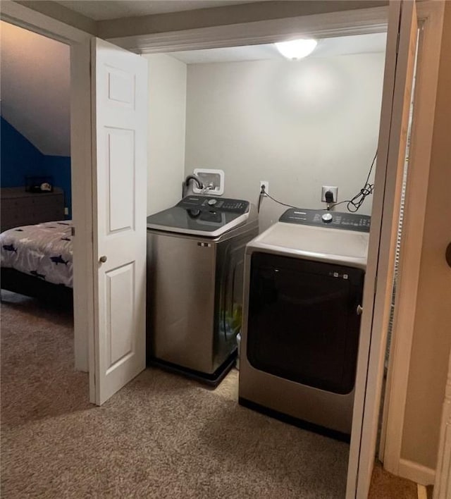 laundry area with washing machine and clothes dryer and light colored carpet