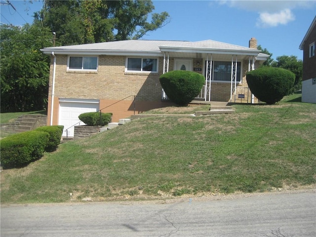 view of front of house featuring a garage, a front yard, and covered porch