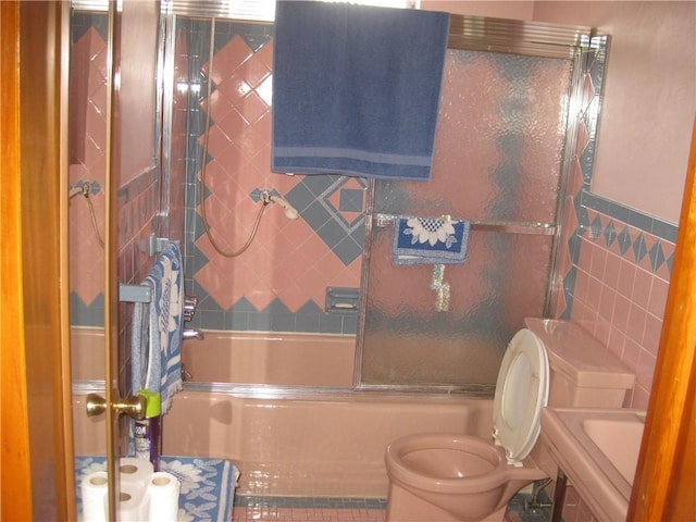 full bathroom with enclosed tub / shower combo, sink, tile walls, and toilet