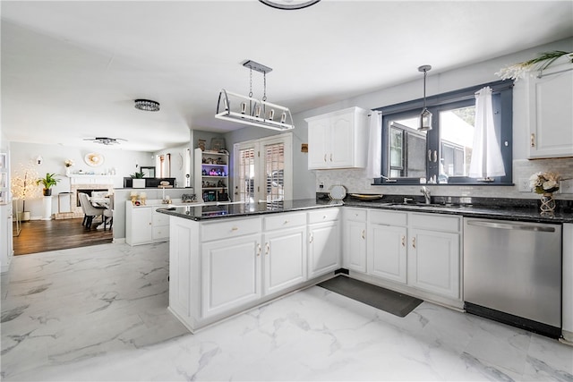 kitchen featuring sink, white cabinetry, decorative light fixtures, stainless steel dishwasher, and kitchen peninsula