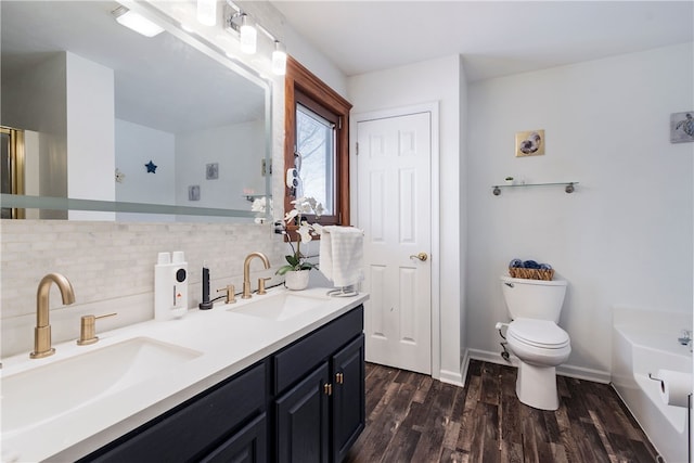 bathroom featuring tasteful backsplash, wood-type flooring, a tub to relax in, vanity, and toilet