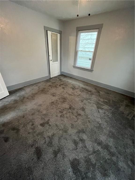 spare room with dark colored carpet