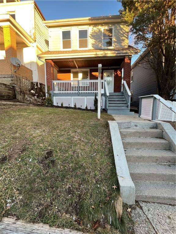 view of property with a front lawn and a porch