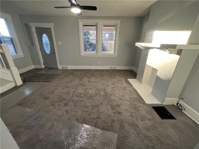 carpeted foyer with a fireplace and ceiling fan