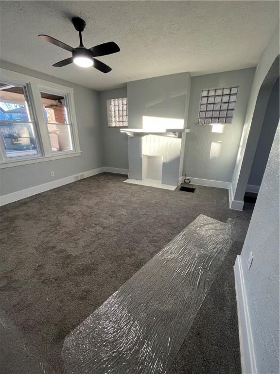 interior space featuring ceiling fan and a textured ceiling