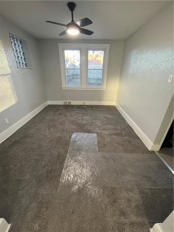 carpeted empty room featuring ceiling fan