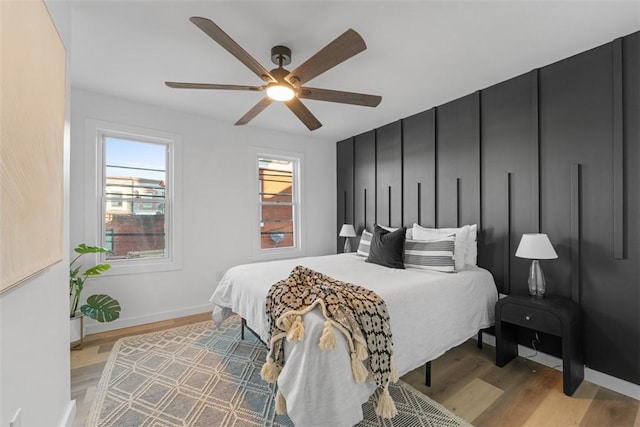 bedroom with light hardwood / wood-style floors and ceiling fan