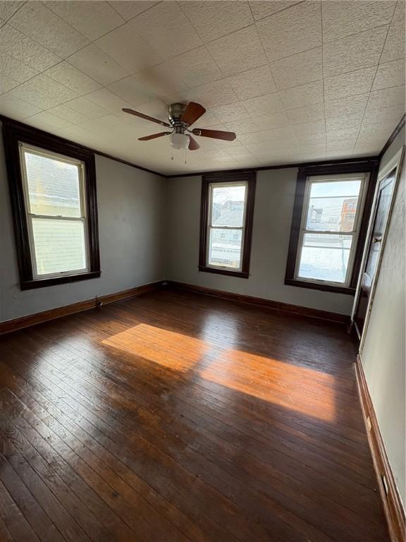 spare room featuring dark wood-type flooring and ceiling fan