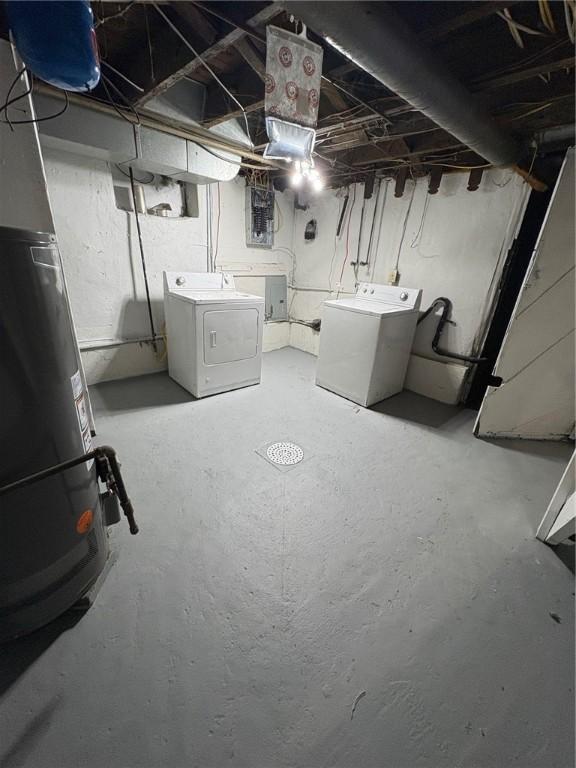 basement with electric panel, washer and clothes dryer, and gas water heater