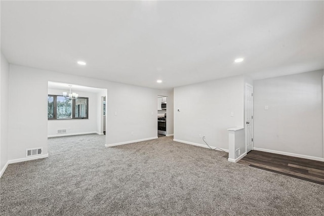 unfurnished room featuring carpet floors and a chandelier