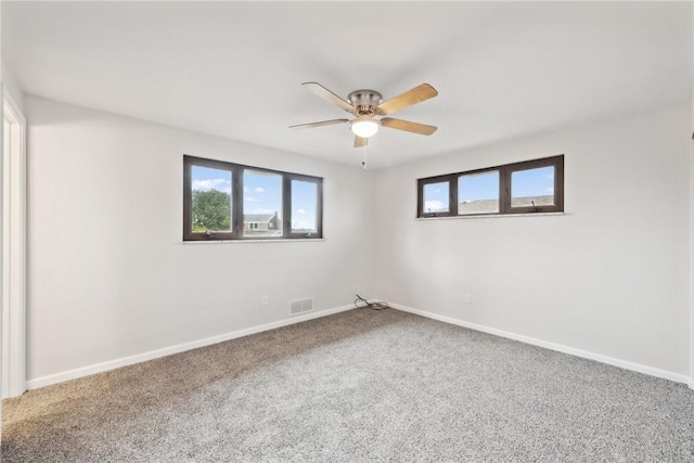 carpeted spare room with ceiling fan