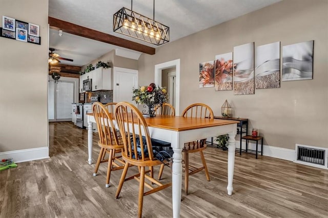 dining area featuring hardwood / wood-style flooring, ceiling fan, and beam ceiling