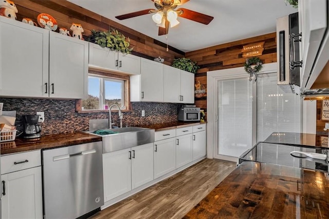 kitchen with hardwood / wood-style flooring, dishwasher, sink, and white cabinets