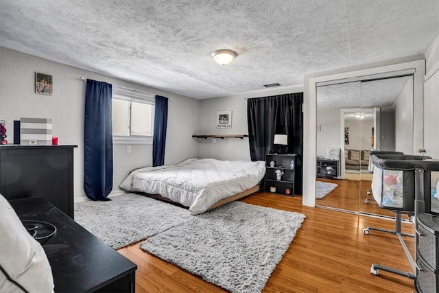 bedroom with hardwood / wood-style floors and a textured ceiling