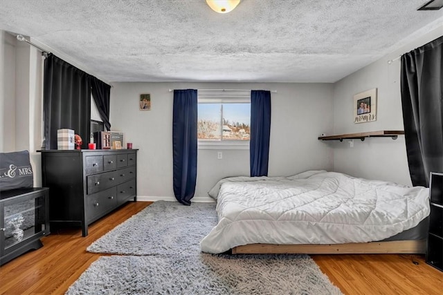 bedroom with hardwood / wood-style flooring and a textured ceiling