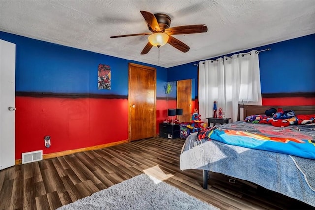 bedroom with hardwood / wood-style floors, a textured ceiling, and ceiling fan