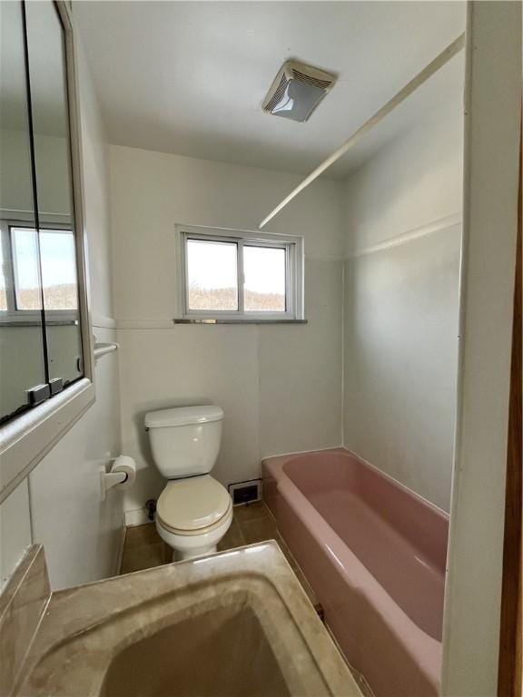 bathroom featuring shower / tub combination and toilet