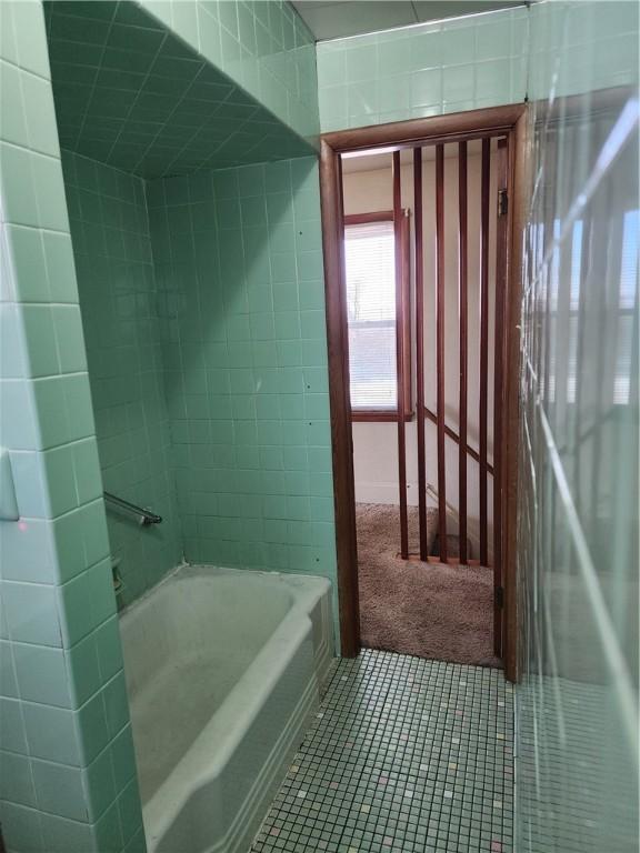 bathroom featuring tile patterned floors and a tub