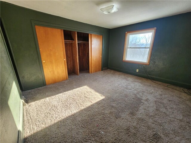 unfurnished bedroom featuring carpet flooring and a closet