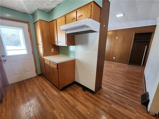 kitchen featuring wooden walls and dark hardwood / wood-style floors