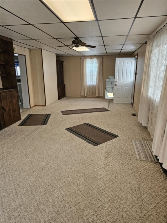 carpeted spare room with a drop ceiling and ceiling fan