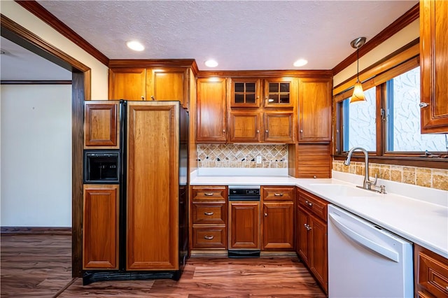 kitchen featuring tasteful backsplash, dishwasher, sink, hanging light fixtures, and paneled refrigerator