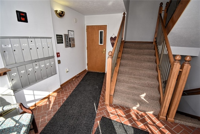 staircase featuring mail boxes and a textured ceiling