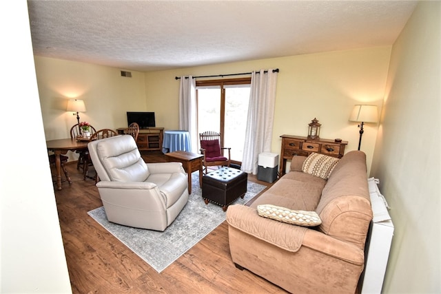 living room with hardwood / wood-style flooring and a textured ceiling