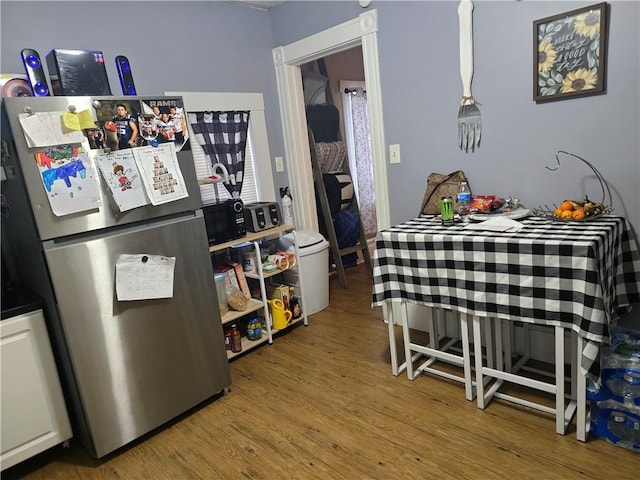 kitchen with hardwood / wood-style flooring and stainless steel refrigerator