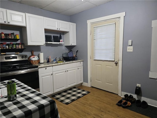 kitchen featuring sink, white cabinets, dark hardwood / wood-style flooring, stainless steel range with electric stovetop, and a drop ceiling