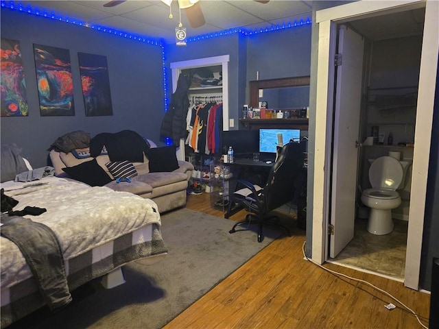 bedroom with hardwood / wood-style floors, a closet, and ceiling fan